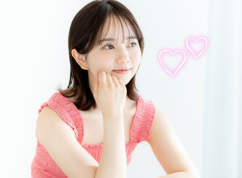 ピンクの洋服を着てほほ笑む女性