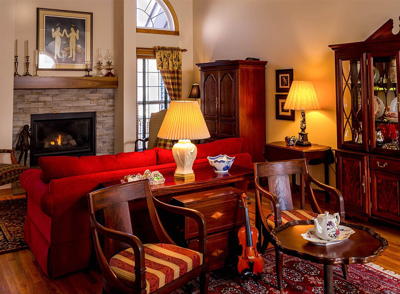 アンティーククラシックの温かみのある部屋。赤いソファや暖炉、オレンジ色に光る間接照明が落ち着いた雰囲気