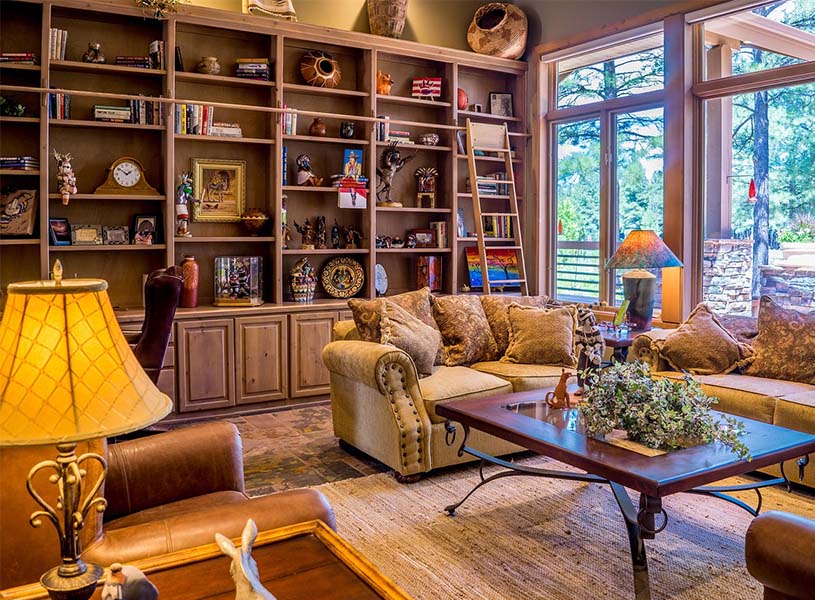 コレクションのような小物が並べられた、博物館のようなシェルフ。レザーのソファやアンティークな照明が味わい深い雰囲気を纏う部屋