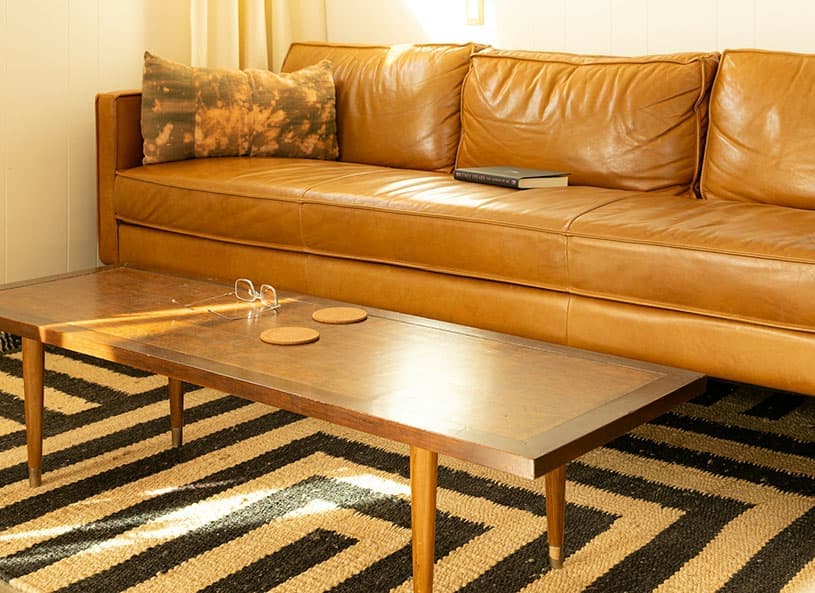 西海岸ヴィンテージインテリアのキャメルカラーのソファーとデニム生地のクッション