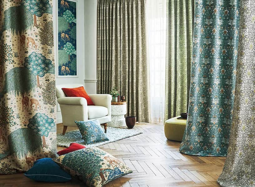 ウィリアムモリスの柄をカーテン、クッションなどを並べて表現しています