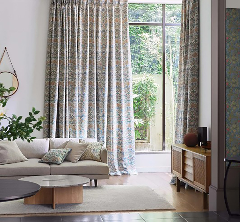 シンプルな家具のあるリビングに下がるウィリアムモリスのカーテン