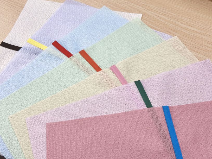 カラフルなバイカラーレースカーテンのサンプルを並べて比較している